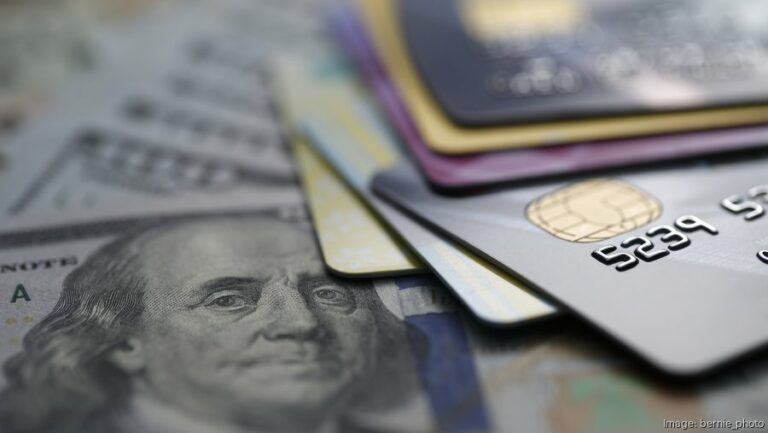 Empresario latino aplicando en línea a un préstamo para consolidar la deuda de tarjetas de crédito empresariales.