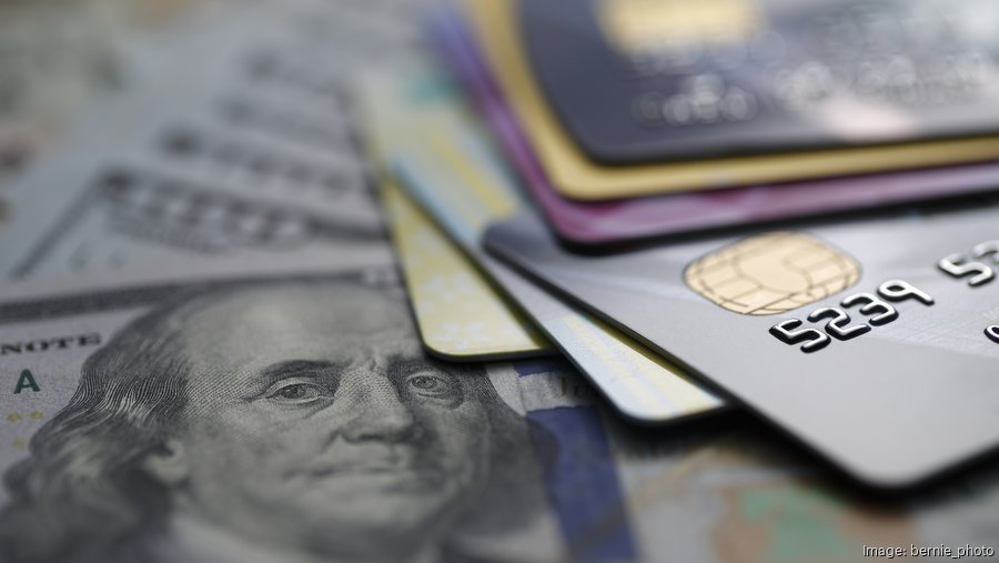 Empresario latino aplicando en línea a un préstamo para consolidar la deuda de tarjetas de crédito empresariales.